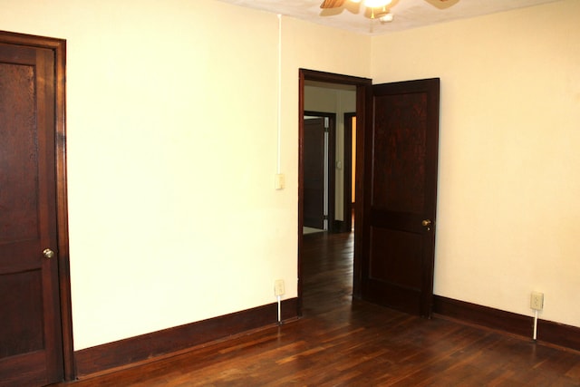 spare room featuring dark wood-type flooring and ceiling fan