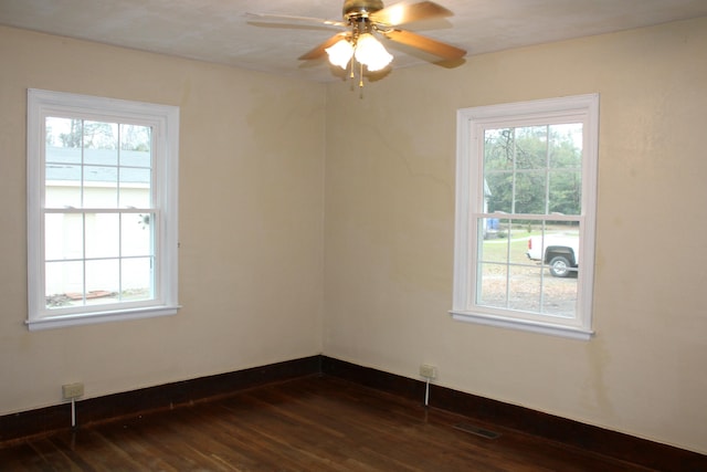 spare room with dark hardwood / wood-style flooring and ceiling fan