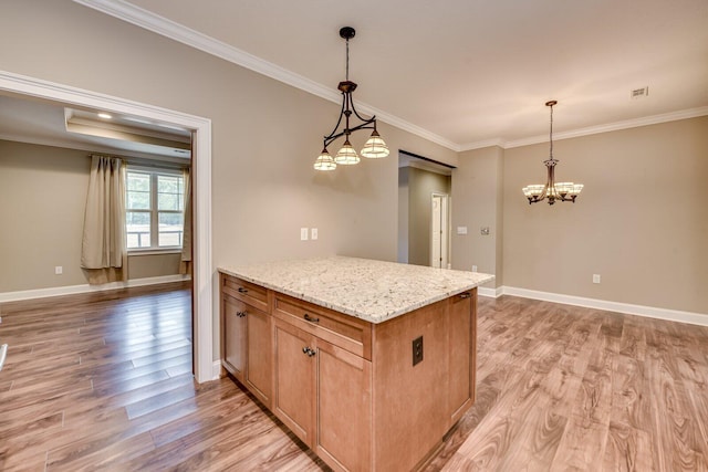 kitchen featuring hanging light fixtures, crown molding, light stone counters, and light hardwood / wood-style flooring