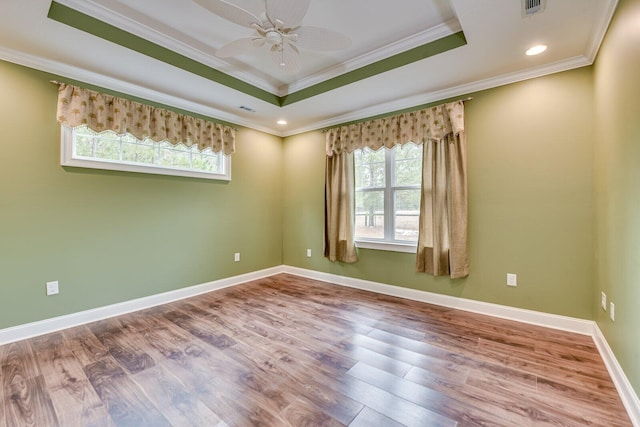 unfurnished room with crown molding, hardwood / wood-style floors, ceiling fan, and a tray ceiling