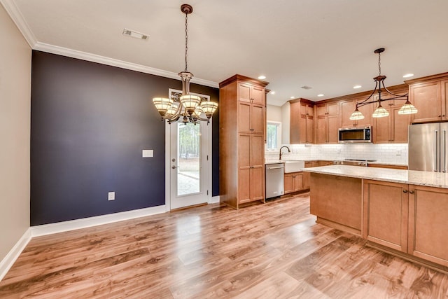 kitchen with light stone counters, appliances with stainless steel finishes, decorative light fixtures, and decorative backsplash