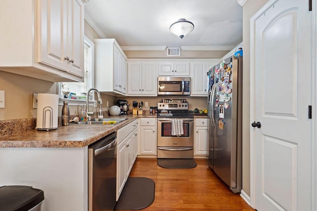 2009 Dundee Way, Grovetown, GA 30813 - kitchen with stainless steel appliances, white cabinetry, crown molding, and light wood-style floors