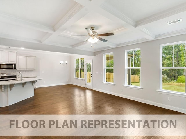 unfurnished living room with beamed ceiling, ceiling fan with notable chandelier, and coffered ceiling