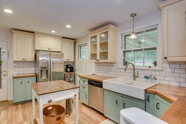 3122 Ramsgate Rd, Augusta, GA 30909 - kitchen featuring butcher block counters, stainless steel appliances, green cabinets, tasteful backsplash, and decorative light fixtures