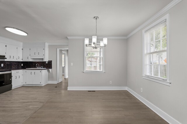 2638 Central Ave, Augusta, GA 30904 - kitchen featuring stove, crown molding, a chandelier, and under cabinet range hood