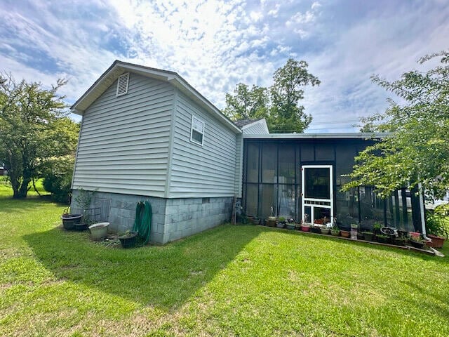 exterior space featuring a sunroom and a yard