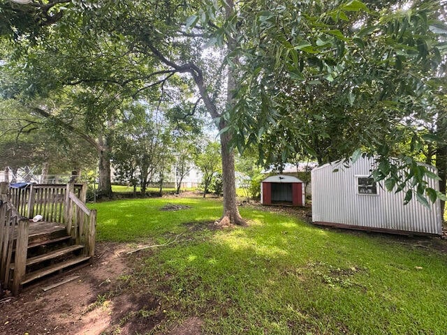 view of yard featuring a wooden deck and a shed