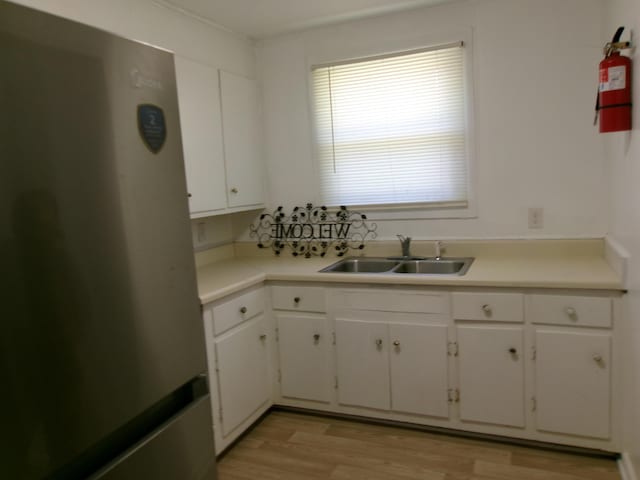 2524 Elderberry Dr, Augusta, GA 30906 - kitchen featuring white cabinetry, a sink, light countertops, freestanding refrigerator, and light wood finished floors