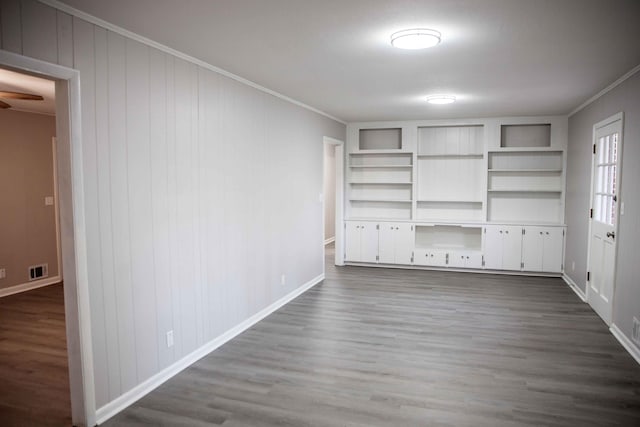 interior space with built in features, wood-type flooring, and ornamental molding