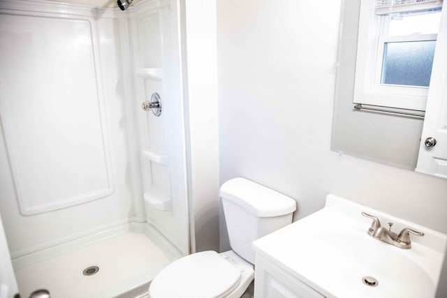 bathroom featuring vanity, toilet, and walk in shower