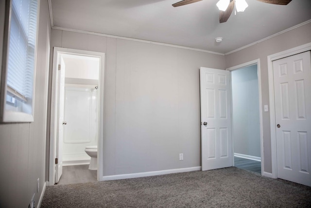 unfurnished bedroom featuring connected bathroom, dark colored carpet, crown molding, a closet, and ceiling fan