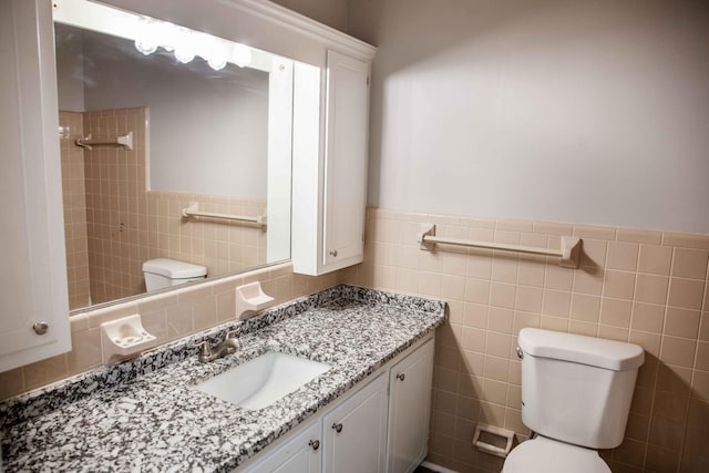 bathroom featuring vanity, tile walls, toilet, and tiled shower