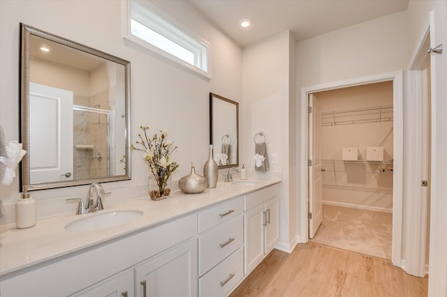 bathroom featuring a shower with door, vanity, and wood-type flooring