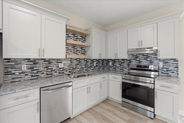 239 Walker St, Augusta, GA 30901 - kitchen with appliances with stainless steel finishes, open shelves, under cabinet range hood, a sink, and light wood-style flooring