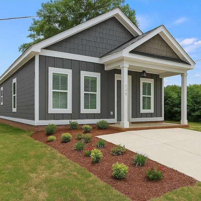 239 Walker St, Augusta, GA 30901 - view of front facade with board and batten siding, covered porch, and a front lawn