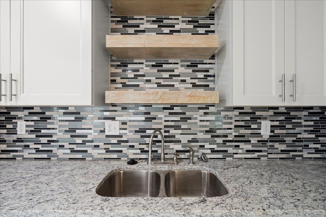 239 Walker St, Augusta, GA 30901 - kitchen view of a sink, tasteful backsplash, white cabinetry, and light stone counters