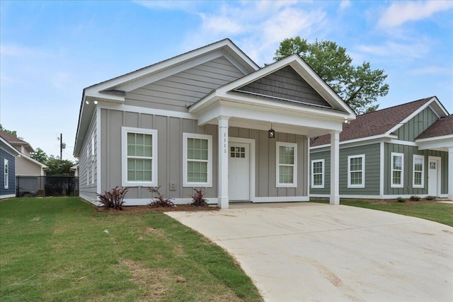 239 Walker St, Augusta, GA 30901 - view of front facade with board and batten siding, a front lawn, driveway, and covered porch
