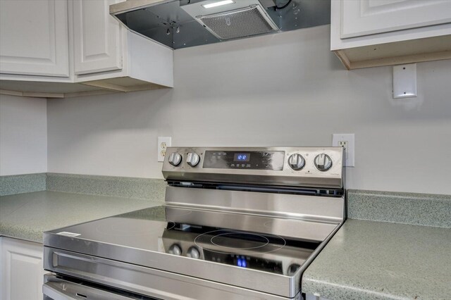 kitchen featuring ventilation hood, white cabinets, electric range, and light countertops
