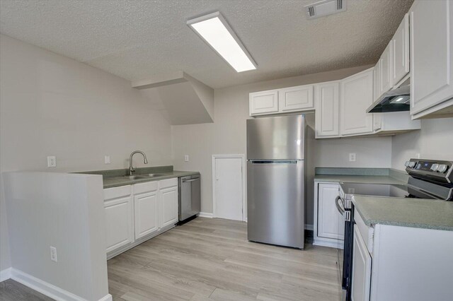 kitchen featuring visible vents, appliances with stainless steel finishes, under cabinet range hood, a sink, and light wood finished floors