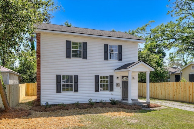 view of front of property featuring a front lawn and fence