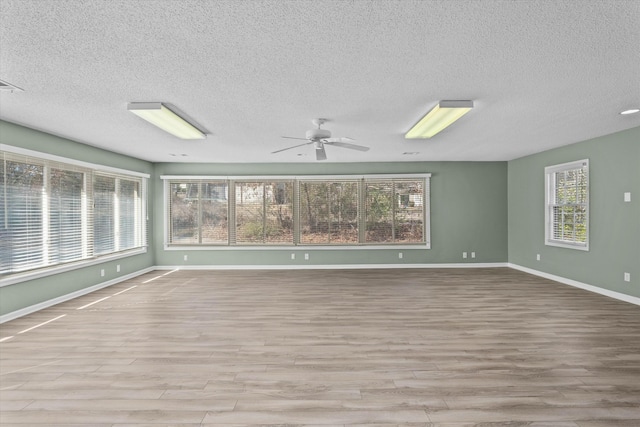 spare room featuring a textured ceiling, ceiling fan, and light hardwood / wood-style flooring