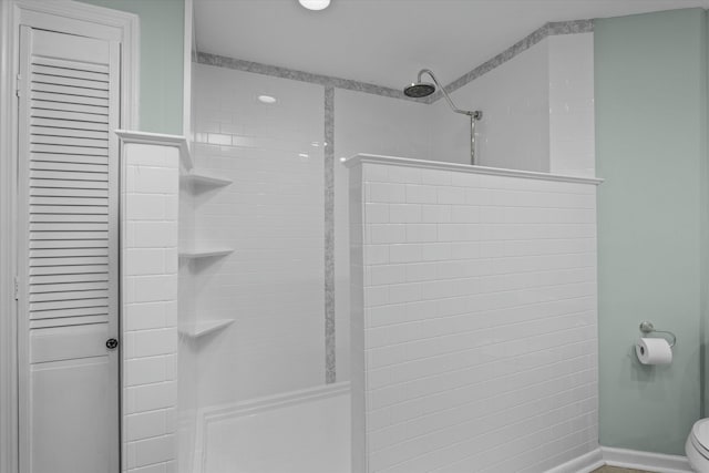 bathroom with toilet and tiled shower