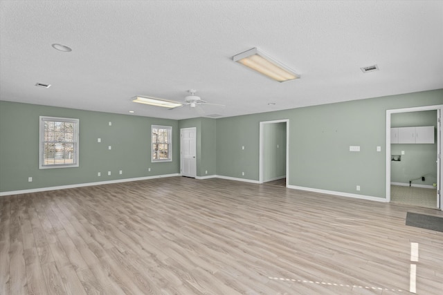 unfurnished room with ceiling fan, light hardwood / wood-style floors, and a textured ceiling