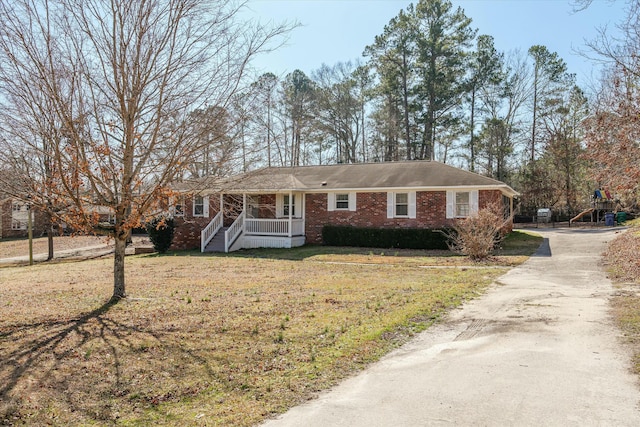 ranch-style home featuring a front yard and covered porch