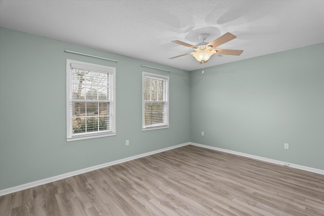 spare room with ceiling fan, light hardwood / wood-style floors, and a textured ceiling