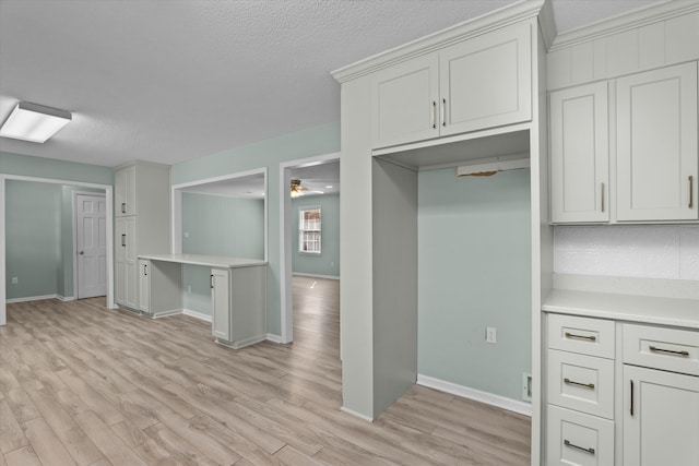 kitchen featuring white cabinetry, a textured ceiling, and light wood-type flooring