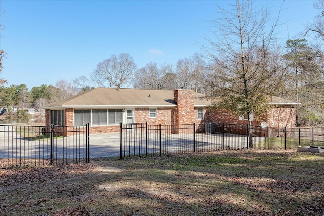 back of house with a swimming pool and a sunroom