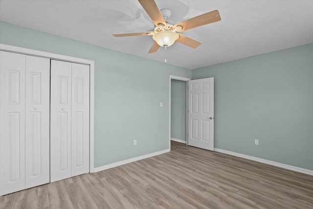 unfurnished bedroom with light hardwood / wood-style flooring, a closet, and ceiling fan