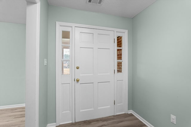 entrance foyer with a textured ceiling and light wood-type flooring