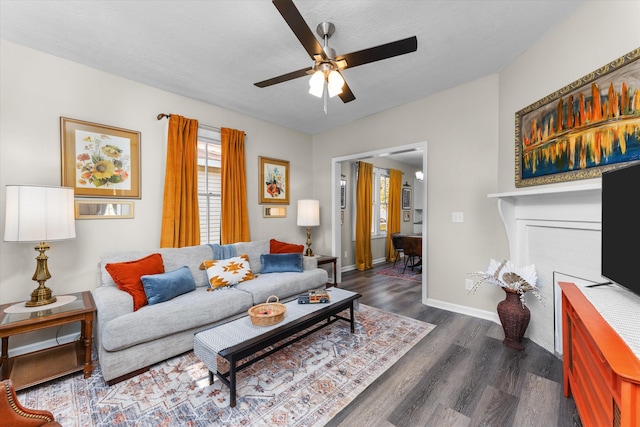 living room with ceiling fan, dark wood-type flooring, and a textured ceiling