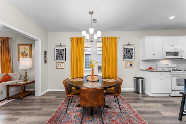 dining space featuring dark hardwood / wood-style flooring and a chandelier