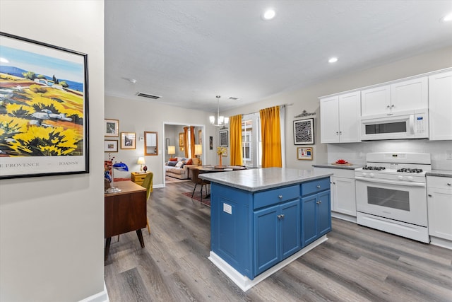 kitchen featuring white appliances, blue cabinets, a kitchen island, pendant lighting, and white cabinetry