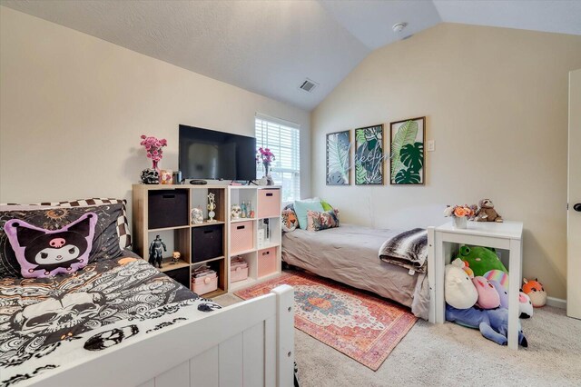 carpeted bedroom with a textured ceiling and vaulted ceiling