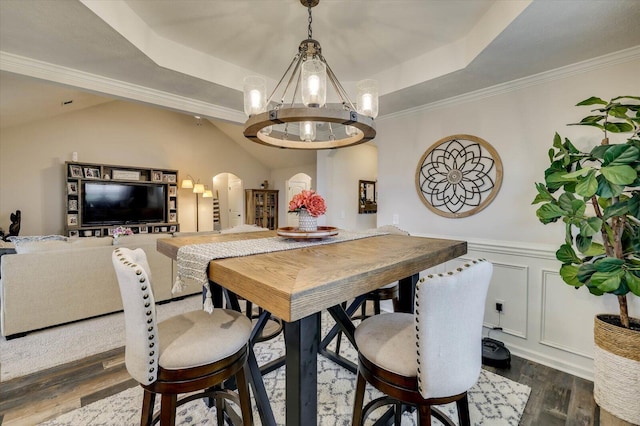 dining area featuring a tray ceiling, crown molding, dark hardwood / wood-style flooring, and an inviting chandelier