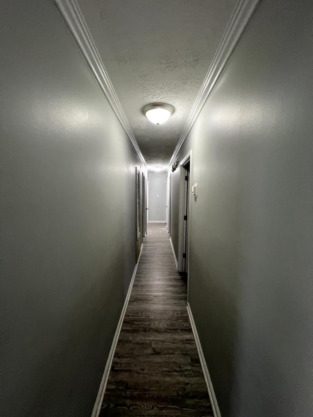 hallway with crown molding, dark hardwood / wood-style floors, and a textured ceiling