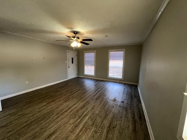 spare room featuring ceiling fan, dark hardwood / wood-style flooring, ornamental molding, and a textured ceiling