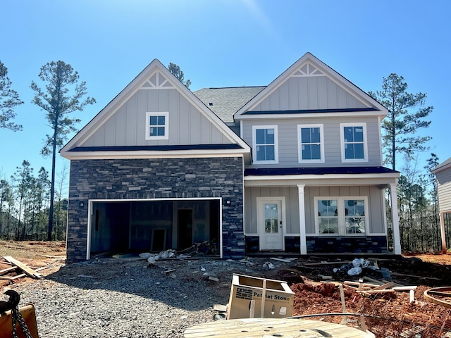 craftsman-style home with driveway, a garage, a shingled roof, stone siding, and board and batten siding