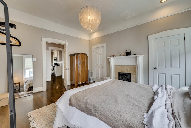1202 Hickman Rd, Augusta, GA 30904 - bedroom with wood finished floors, a chandelier, a fireplace, and baseboards