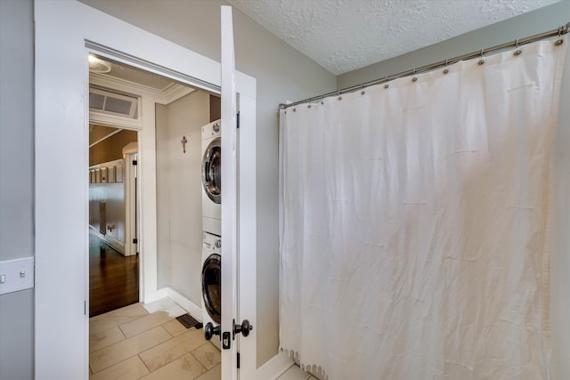 1202 Hickman Rd, Augusta, GA 30904 - washroom featuring stacked washing machine and dryer, baseboards, and a textured ceiling