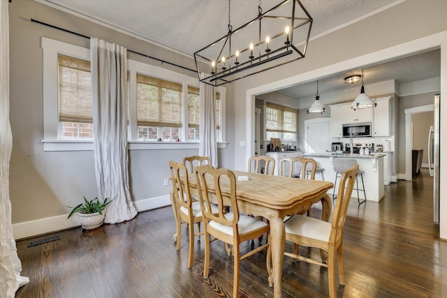 1202 Hickman Rd, Augusta, GA 30904 - dining room with dark wood-type flooring, a chandelier, baseboards, and ornamental molding