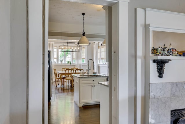 1202 Hickman Rd, Augusta, GA 30904 - kitchen featuring a sink, white cabinets, dark wood-type flooring, a chandelier, and stone counters