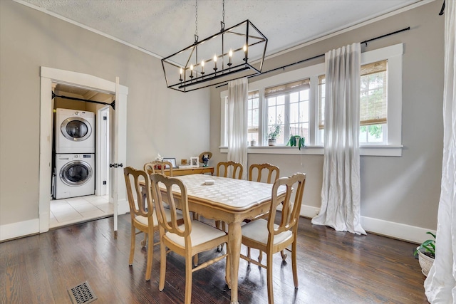 1202 Hickman Rd, Augusta, GA 30904 - dining room featuring estacked washer and dryer, crown molding, wood finished floors, a textured ceiling, and baseboards