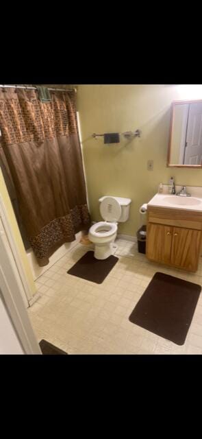 bathroom featuring vanity, a shower with shower curtain, and toilet