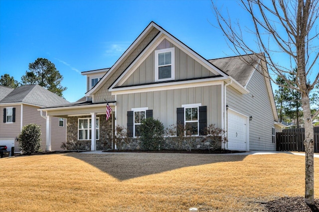 craftsman-style home with an attached garage, board and batten siding, a front yard, and fence