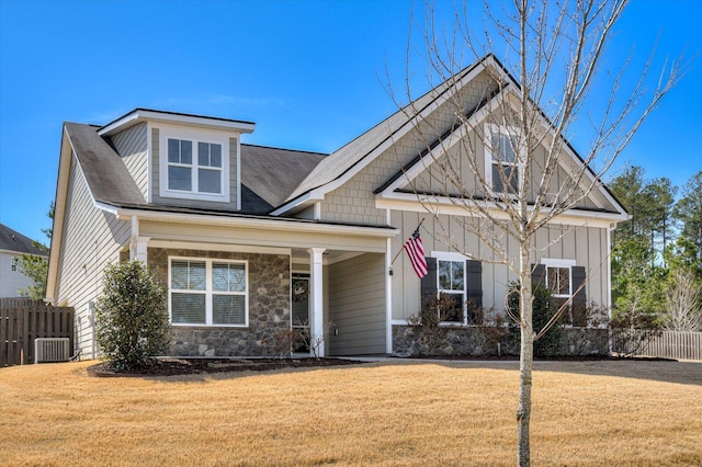 craftsman-style house featuring board and batten siding, a front lawn, and fence