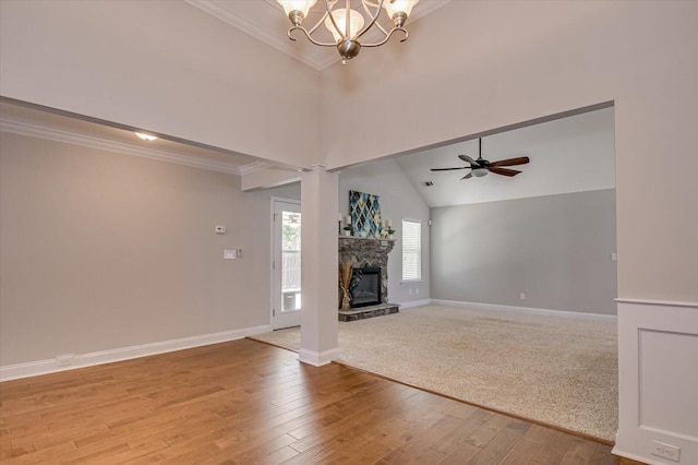 unfurnished living room featuring a stone fireplace, crown molding, light wood-style flooring, and high vaulted ceiling